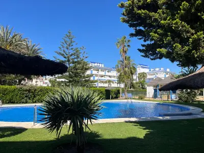 a swimming pool in front of a large building at Apartamento en Costa Ballena, Urb. Playa Ballena in Cádiz