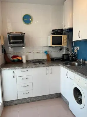 a small kitchen with a sink and a microwave at Apartamento en Costa Ballena, Urb. Playa Ballena in Cádiz