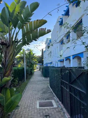 a brick sidewalk next to a building with a fence at Apartamento en Costa Ballena, Urb. Playa Ballena in Cádiz