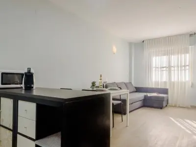 a living room with a table and a couch at Aparta-club la Barrosa 116 in Chiclana de la Frontera