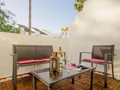 a table and two chairs on a patio at Aparta-club la Barrosa 116 in Chiclana de la Frontera