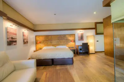 a hotel room with a bed and a couch at Apartamentos El Roqueo in Conil de la Frontera