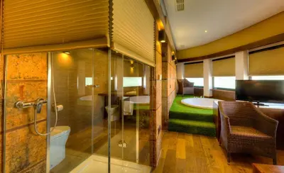 a bathroom with a shower and a toilet and a television at Apartamentos El Roqueo in Conil de la Frontera
