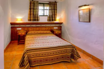 a bed in a room with a blanket on it at Apartamentos El Roqueo in Conil de la Frontera