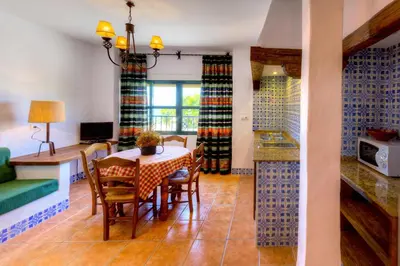a kitchen and dining room with a table and chairs at Apartamentos El Roqueo in Conil de la Frontera
