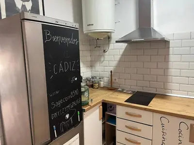 a kitchen with a refrigerator with a chalkboard on it at 50m Playa Caleta y Teatro Falla Grupo AC Gestion in Cádiz