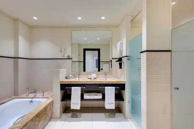 a bathroom with a tub and a large mirror at Royal Hideaway Sancti Petri in Chiclana de la Frontera