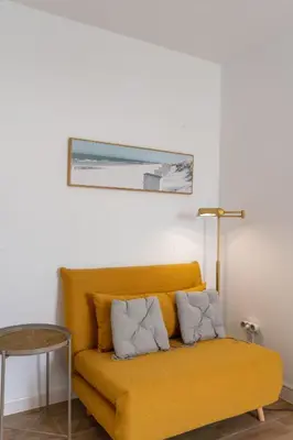 a yellow couch in a room with a table at Azotea Rooftop Playa la Caleta in Cádiz