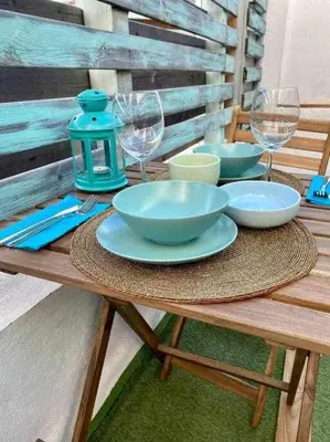 a wooden table with bowls and wine glasses on it at Azotea Rooftop Playa la Caleta in Cádiz