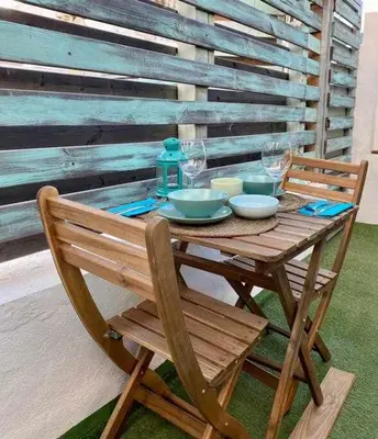 a wooden table with bowls and wine glasses on it at Azotea Rooftop Playa la Caleta in Cádiz
