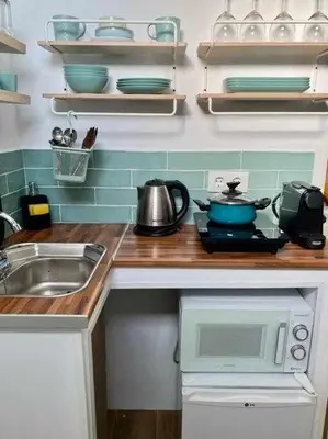 a kitchen counter with a sink and a microwave at Azotea Rooftop Playa la Caleta in Cádiz