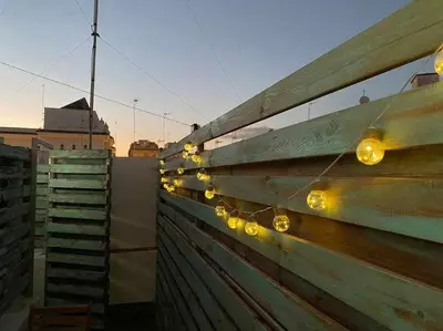 a wooden fence with lights on top of it at Azotea Rooftop Playa la Caleta in Cádiz