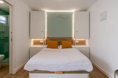 a bedroom with a bed with two orange pillows at Azotea Rooftop Playa la Caleta in Cádiz