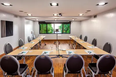 a conference room with wooden tables and chairs at Occidental Cádiz in Cádiz