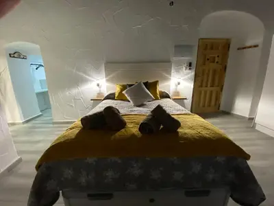 a bedroom with a large bed with yellow sheets and pillows at Apartamento Jerez Sherry in Jerez de la Frontera
