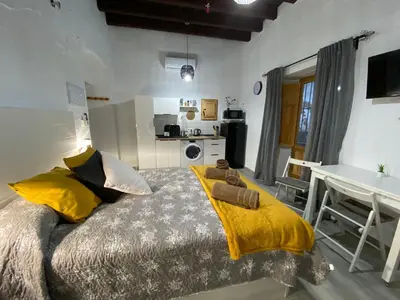 a bedroom with a bed with a yellow blanket on it at Apartamento Jerez Sherry in Jerez de la Frontera