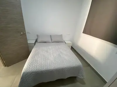 a white bed in a white room with at APARTAMENTOS PASCUAL in El Cuervo
