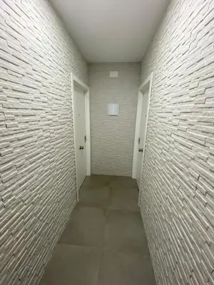 a hallway with two doors and a brick wall at APARTAMENTOS PASCUAL in El Cuervo
