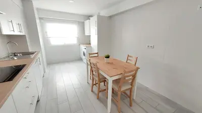 a kitchen with a wooden table and chairs in a room at PISABEL in Sanlúcar de Barrameda