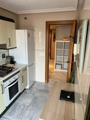 a kitchen with a white refrigerator and a stove top oven at Ático primera línea de playa. in Cádiz