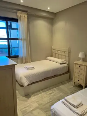 a bedroom with two beds and a window at Ático primera línea de playa. in Cádiz