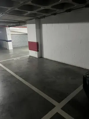 an empty parking garage with a white wall at Ático primera línea de playa. in Cádiz