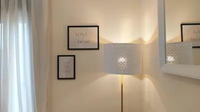 a room with two lights on a wall with pictures at Sherryflat Trébol - Parking in Jerez de la Frontera
