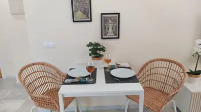 a white table with three chairs and wine glasses at Sherryflat Trébol - Parking in Jerez de la Frontera