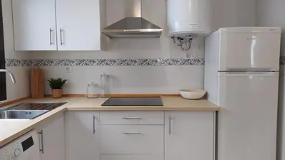 a white kitchen with a sink and a refrigerator at Sherryflat Trébol - Parking in Jerez de la Frontera