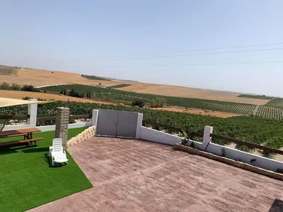 a patio with a table and a bench and grass at Santa Lucía in Jerez de la Frontera