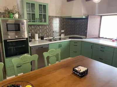 a kitchen with green cabinets and a wooden table at Santa Lucía in Jerez de la Frontera