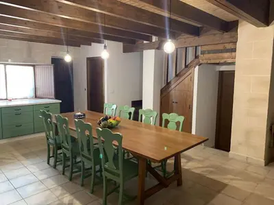 a dining room with a wooden table and green chairs at Santa Lucía in Jerez de la Frontera