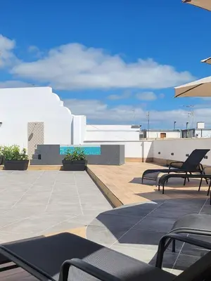 a patio with chairs and tables on a roof at Apartamentos Soho Boutique Palillero in Cádiz