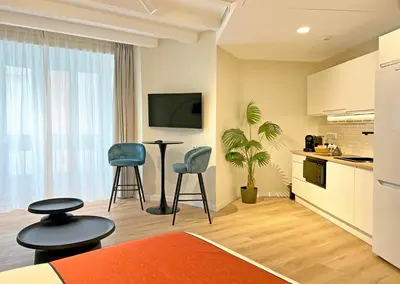 a kitchen with two chairs and a table in a room at Apartamentos Soho Boutique Palillero in Cádiz