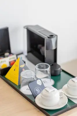 a tray with plates and cups and a coffee maker at Apartamentos Soho Boutique Palillero in Cádiz