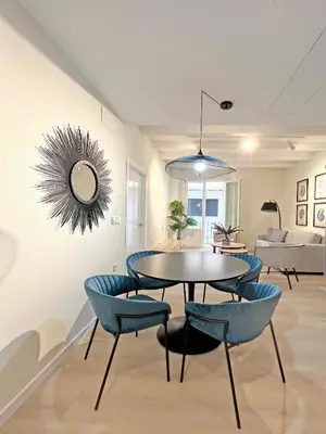 a dining room with a table and blue chairs at Apartamentos Soho Boutique Palillero in Cádiz