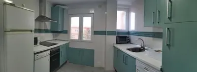 a kitchen with blue and white cabinets and a sink at Estadio 3 in Cádiz