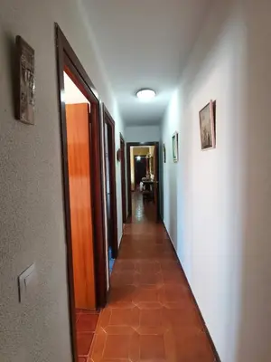 a hallway with a long corridor with white walls and a tile floor at Estadio 3 in Cádiz