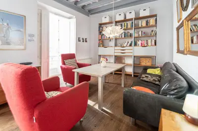 a living room with red chairs and a table at Apartamento Sweet Home in Cádiz in Cádiz