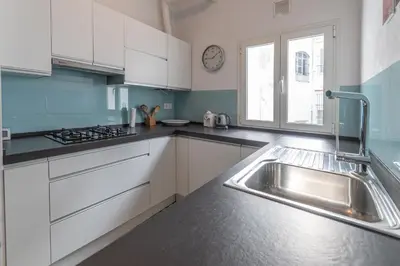 a kitchen with white cabinets and a sink and a window at Apartamento Sweet Home in Cádiz in Cádiz