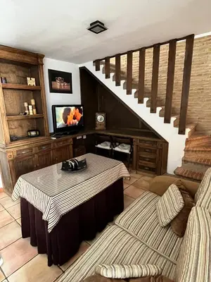 a living room with a table and a staircase at Esencia de Arcos in Arcos de la Frontera