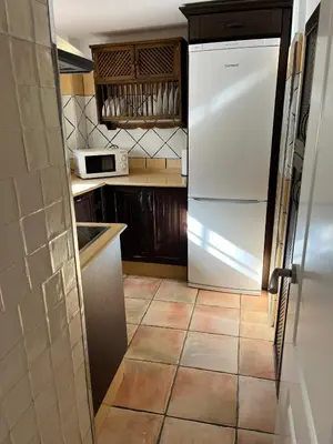 a kitchen with a white refrigerator and a tile floor at Esencia de Arcos in Arcos de la Frontera