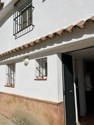 a white building with barred windows and a door at Esencia de Arcos in Arcos de la Frontera