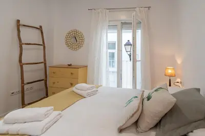 a bedroom with a white bed with towels on it at Apartamento El Bergantin de Cádiz in Cádiz