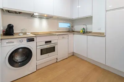 a kitchen with white cabinets and a washing machine at Apartamento El Bergantin de Cádiz in Cádiz