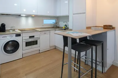 a kitchen with a counter and a washer and dryer at Apartamento El Bergantin de Cádiz in Cádiz