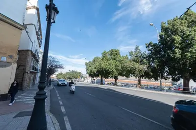 a person riding a scooter down a city street at Apartamento El Bergantin de Cádiz in Cádiz