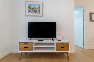 a tv on a white cabinet in a living room at Apartamento El Bergantin de Cádiz in Cádiz