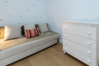 a white bedroom with a bed and a dresser at Apartamento El Bergantin de Cádiz in Cádiz