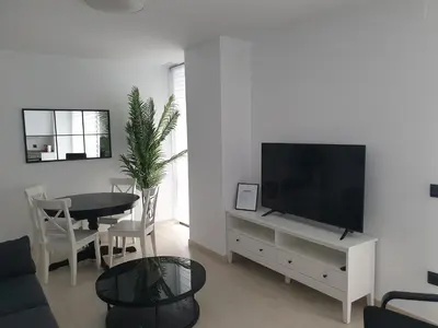 a living room with a flat screen tv and a table at LHOME CÁDIZ in Cádiz